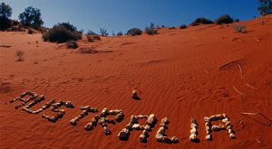 Image of the word Australia written in red dirt and rocks