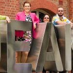 Image of seven of the SPERA Executive members standing in and around the Deakin University sign