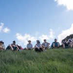 Students sitting on grass hill
